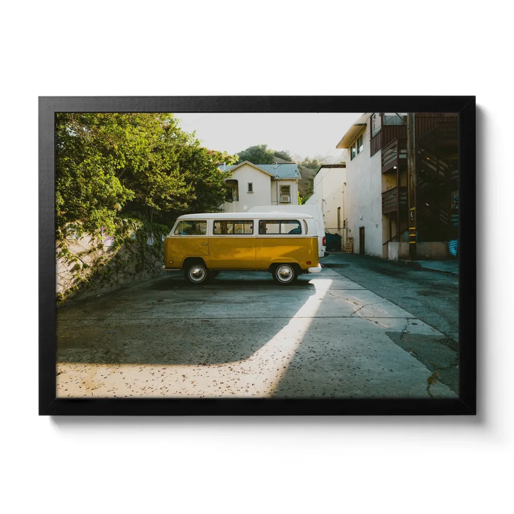 Alter gelber VW Buli der in einer Seitenstraße parkt, dazu cooler Lichteinfall (Vintage Look)