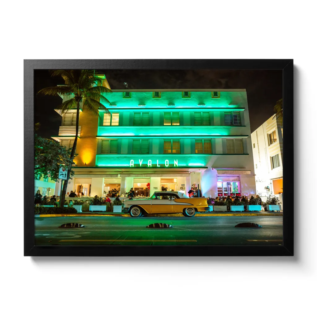 Landscapeaufnahme vom Avalon Hotel Miami am Ocean Drive mit einem gelben Oldtimer davor.