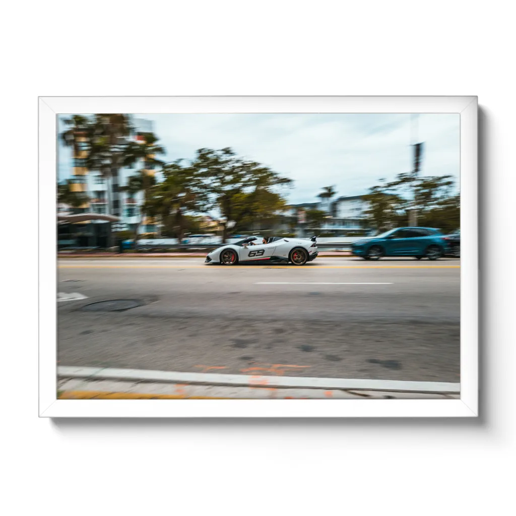 Bildaufnahme eines schnellen weißen Lamborghini der durch Miami flitzt. Aufschrift 69.