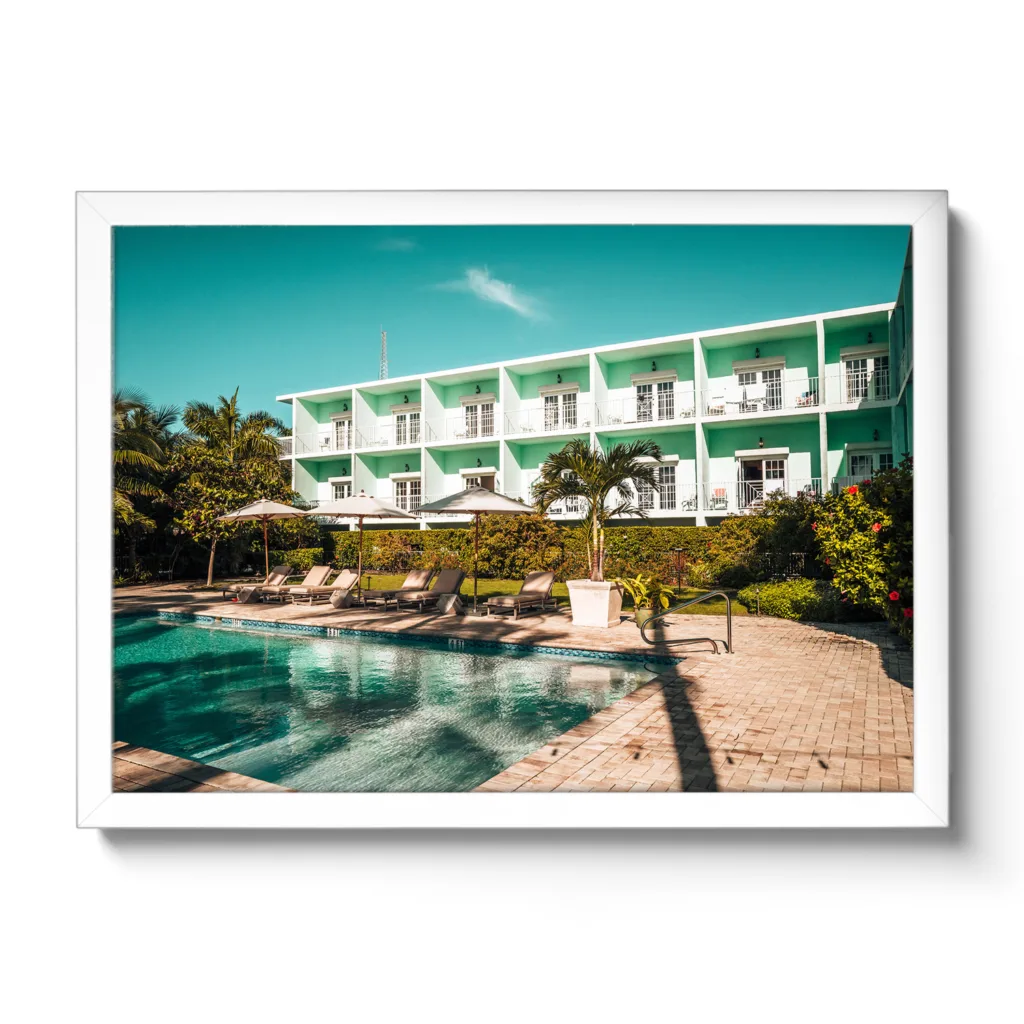 Bildaufnahme des Pool-Bereiches des Grassy Flat Hotel. Blauer Himmel, Pool und Liegen. Morgenansicht.