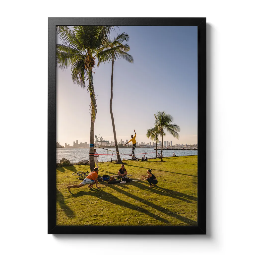Bildaufnahme vom South Pointe Miami, wo ein Mann auf einer Slackline steht und davor eine Yoga-Gruppe.